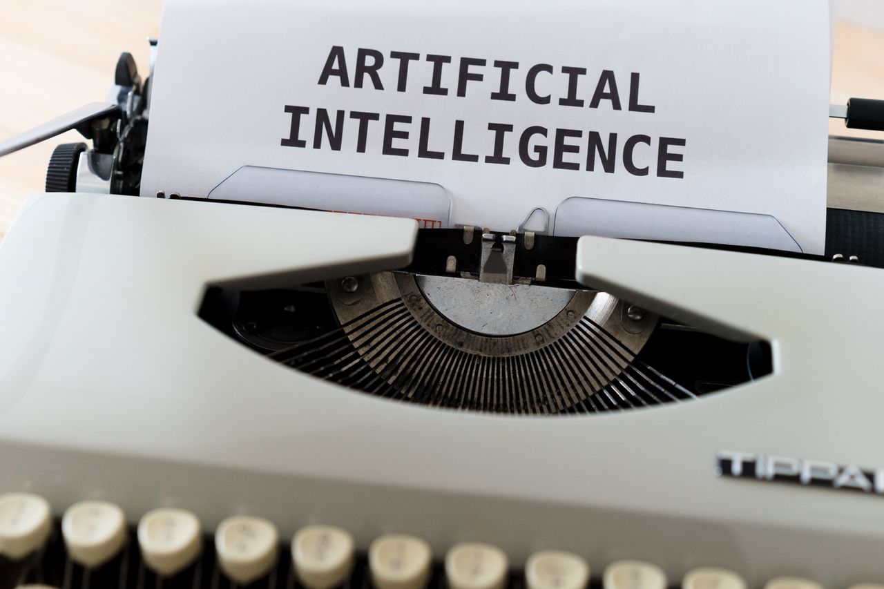 The Art of Drawing Readers In: Your attractive post title goes here A close-up of a typewriter showcasing 'ARTIFICIAL INTELLIGENCE' on paper.