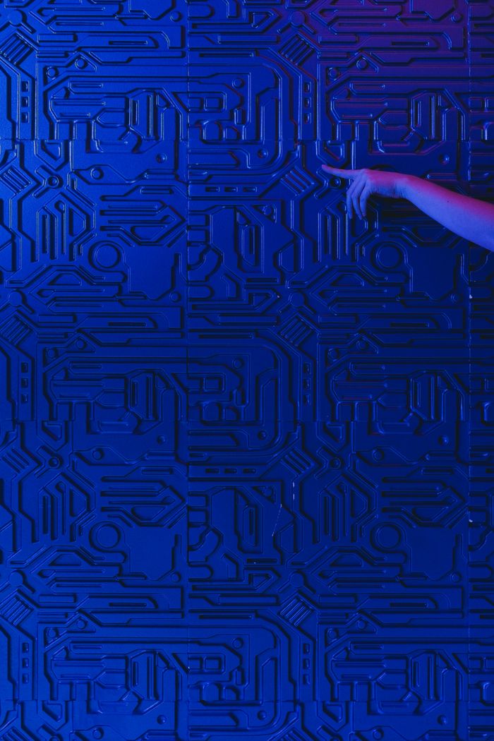 Services A blue circuit board pattern with a human hand pointing, highlighted by blue lighting.